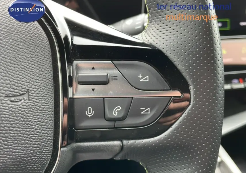 Gros plan sur les commandes multifonctions noires à gauche du volant perforé du Peugeot 408 Hybrid 145ch GT 2024.