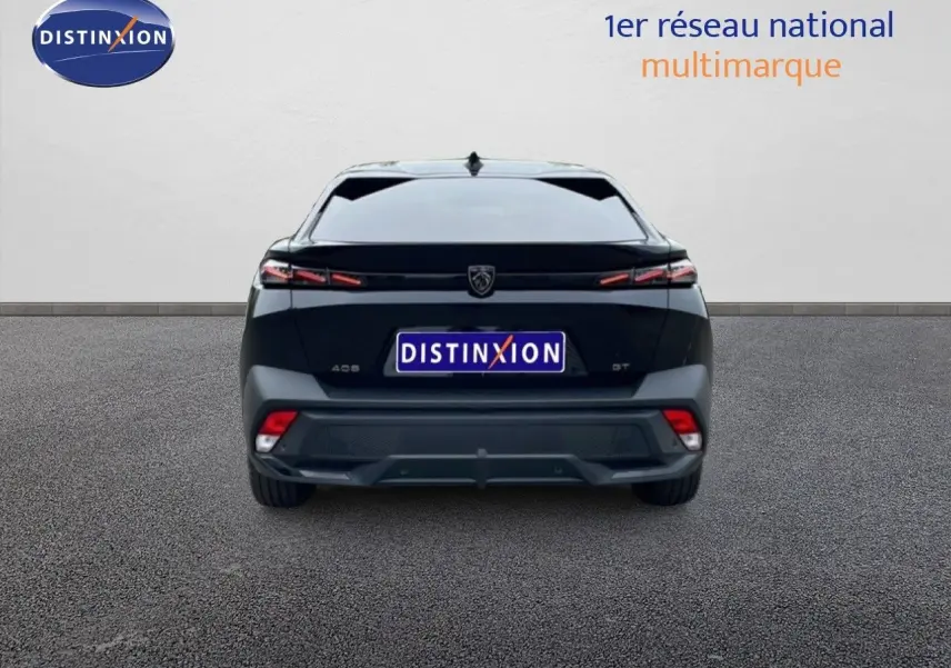 Vue arrière d'une Peugeot 408 HYBRID 145CH GT noire métal, avec feux arrière LED et logo distinctif au centre.