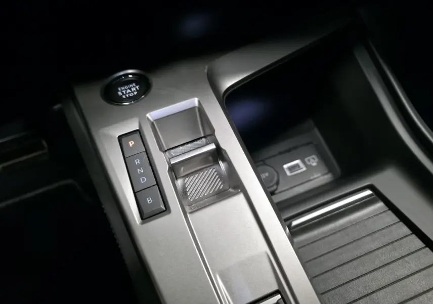 Vue rapprochée de la console centrale grise avec sélecteur de boîte auto et bouton start/stop du Peugeot 408 hybride rechargeable.