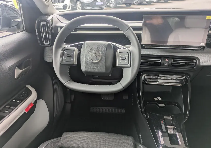 Vue intérieure centrée sur le volant et la console centrale du Citroën C3 Aircross 2026, avec écran tactile et commandes intégrées.