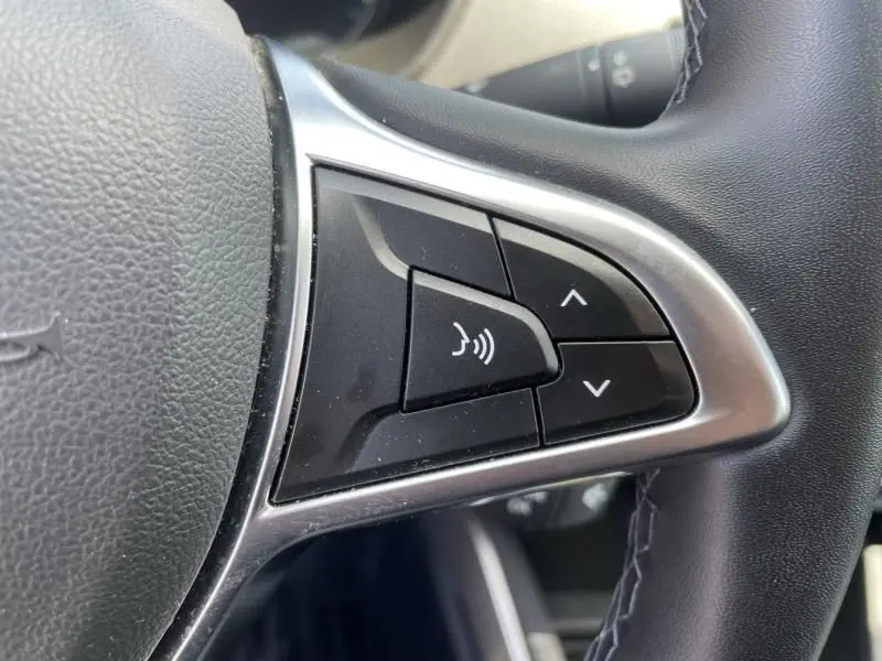 Gros plan sur les commandes audio au volant du Dacia Duster TCE 150 Prestige 4x2 2020, intérieur noir.