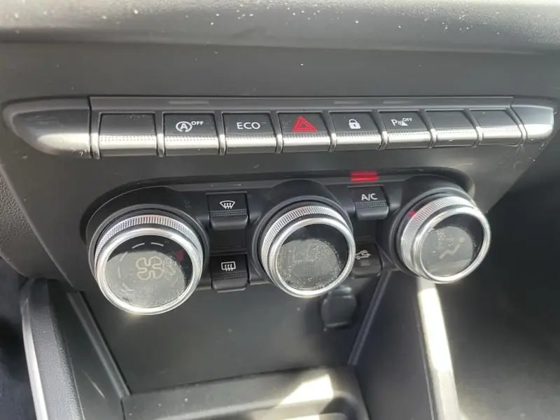 Gros plan sur les commandes de climatisation et les boutons de fonction du tableau de bord du Dacia Duster rouge métal 2020.