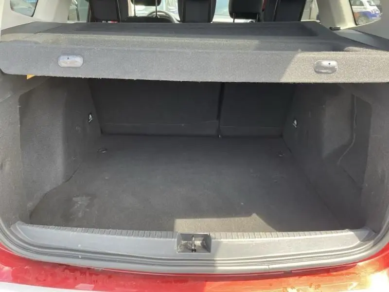 Coffre ouvert du Dacia Duster TCE 150 Prestige 4x2 rouge métal 2020, vue arrière montrant l’espace de chargement vide.