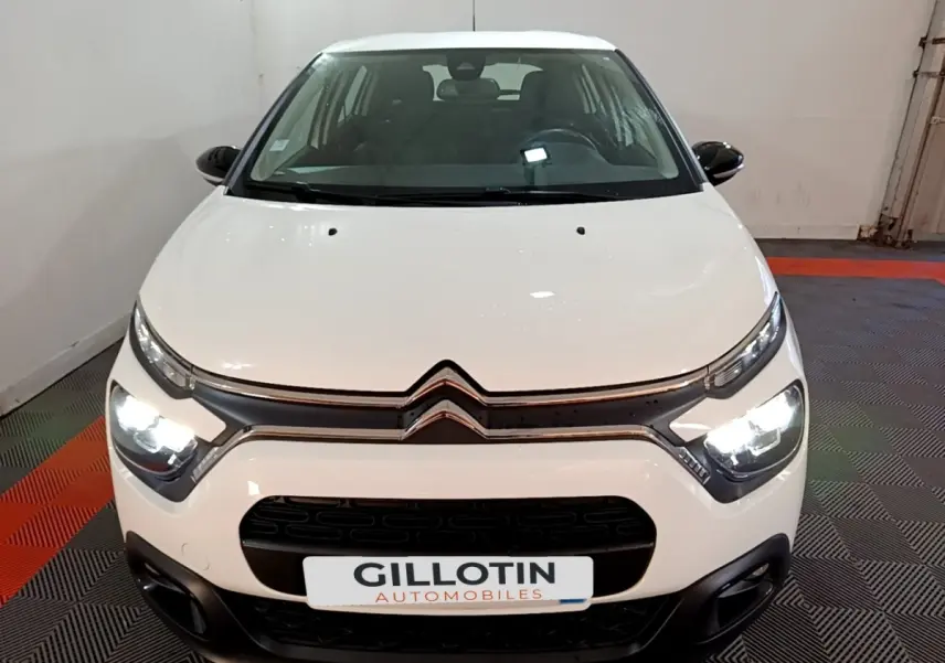 Vue avant d'une Citroën C3 blanche 2020 avec phares allumés et calandre noire distinctive.