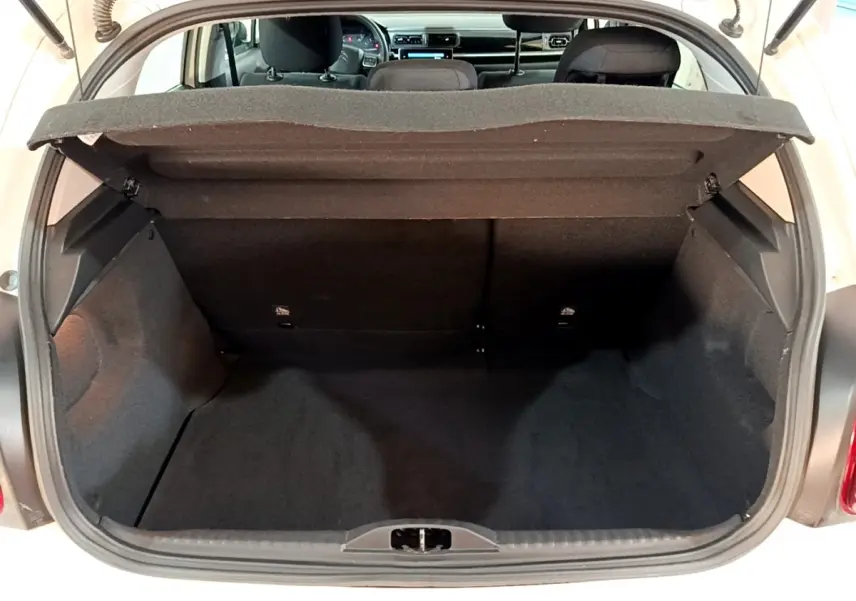 Coffre ouvert d'une Citroën C3 blanche 2020, vue arrière montrant l'espace de chargement et l'intérieur noir.