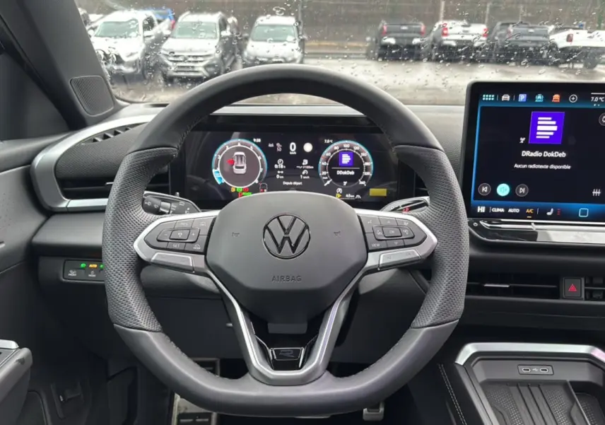 Vue intérieure centrée sur le volant cuir multifonctions du Volkswagen T-Roc 2026 avec tableau de bord digital et écran tactile.