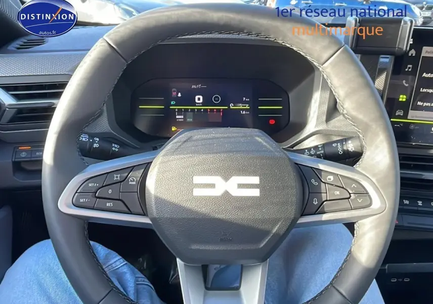 Vue intérieure centrée sur le volant cuir noir multifonction du Dacia Duster 2026 avec tableau de bord numérique.