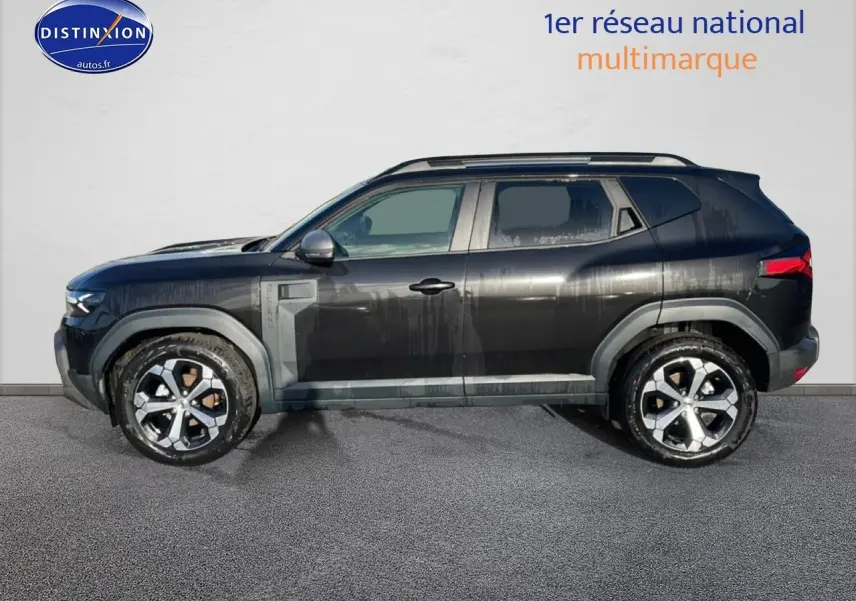 Profil côté gauche du Dacia Duster noir 2026 avec jantes alu et barres de toit visibles.