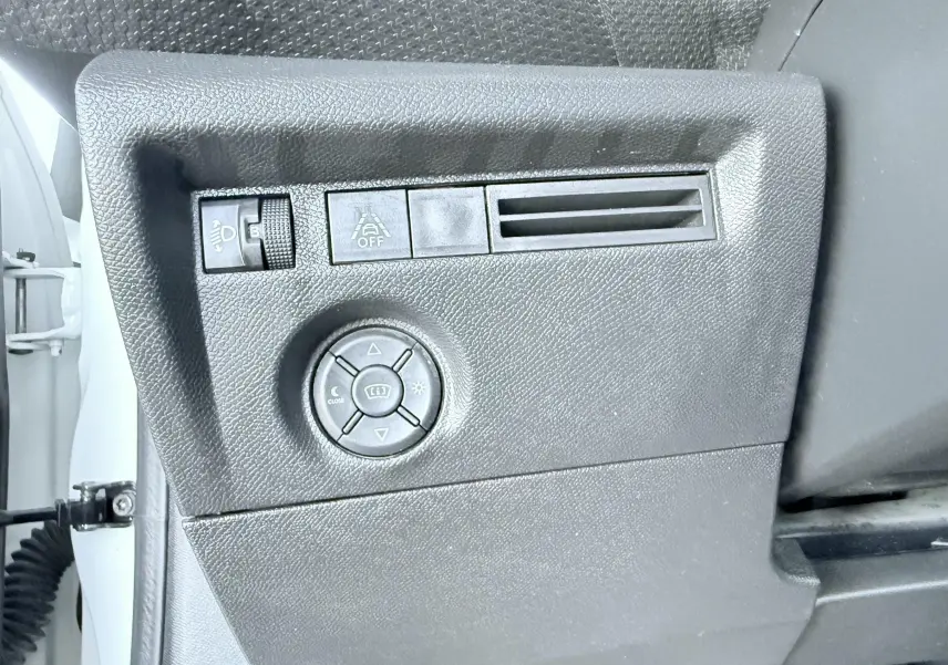 Vue rapprochée du panneau de commandes latéral noir à gauche dans une Citroën C4 blanche de 2023.