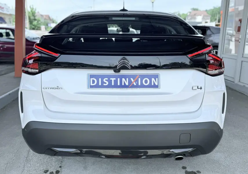 Vue arrière d'une Citroën C4 blanche 2023 avec toit noir et feux arrière LED distinctifs.