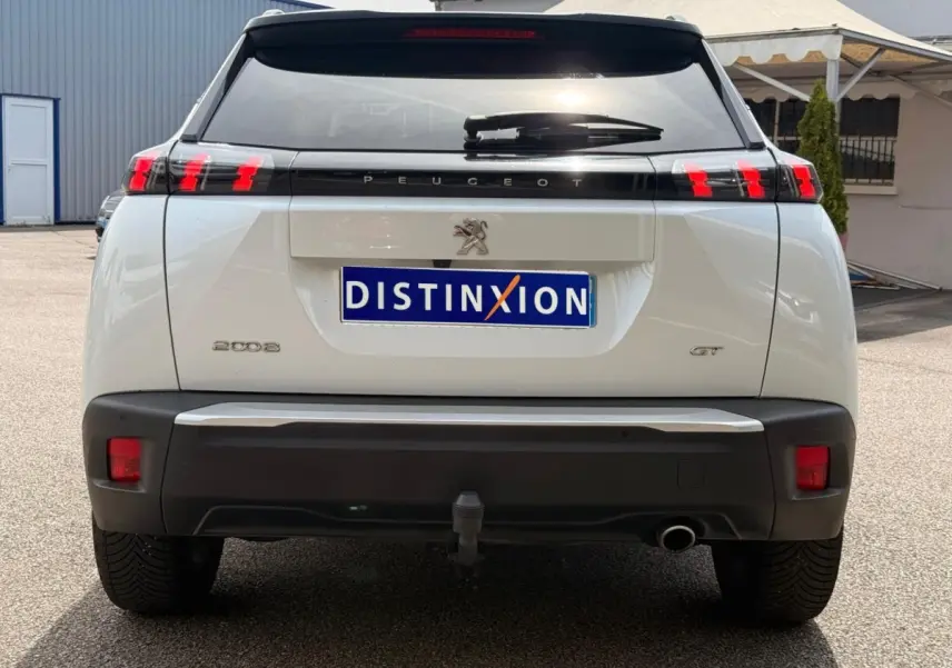 Vue arrière d’un Peugeot 2008 blanc de 2021 avec feux LED caractéristiques et attelage visible.