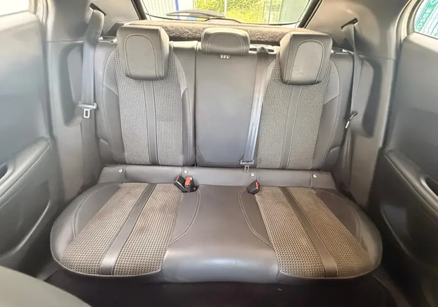 Vue arrière intérieure montrant la banquette arrière en sellerie tri-matière gris foncé du Peugeot 2008 blanc de 2021.