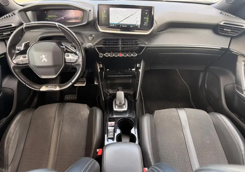 Vue intérieure avant du Peugeot 2008 blanc de 2021, montrant le tableau de bord, volant compact et écran tactile central.