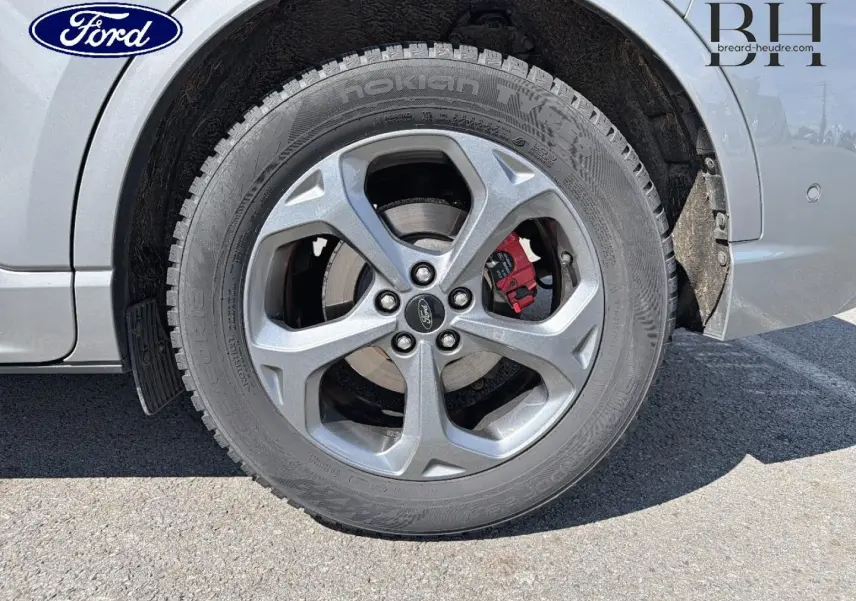 Gros plan sur la roue avant droite du Ford Kuga gris Solar Métallisé avec étrier de frein rouge visible.