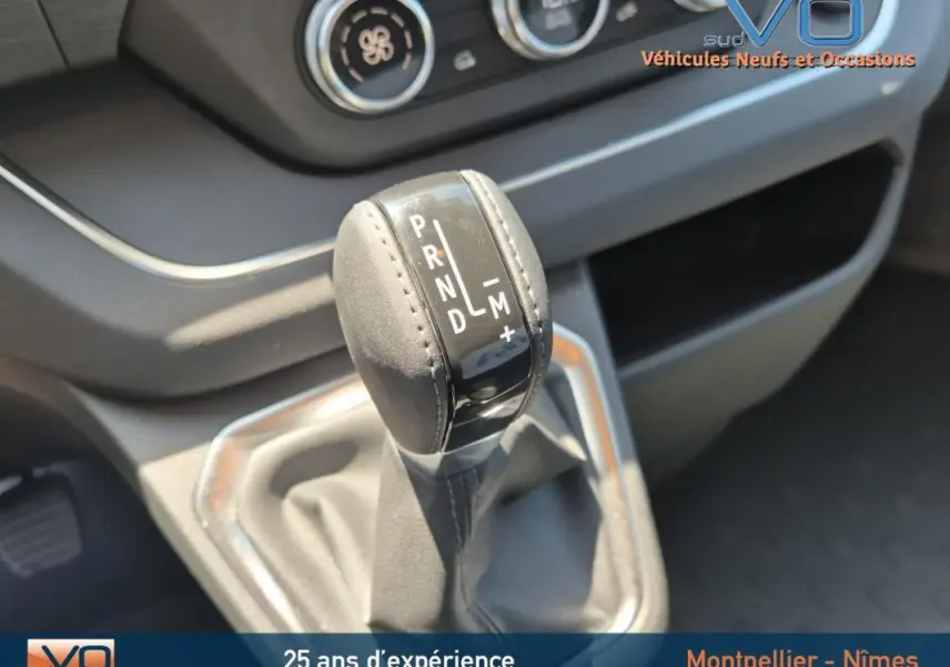 Le levier de vitesses automatique en cuir du Renault Trafic Fourgon gris foncé, vue rapprochée de la console centrale.