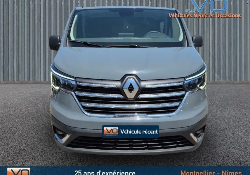Vue frontale du Renault Trafic Fourgon gris foncé 2023 avec calandre chromée et feux LED allumés.