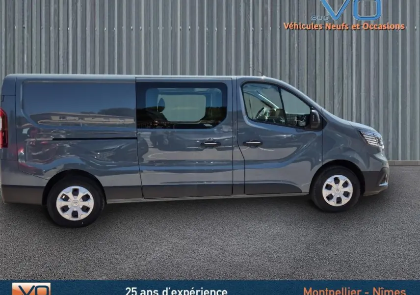 Profil côté gauche d’un Renault Trafic Fourgon gris foncé 2023 avec porte latérale vitrée et jantes acier.