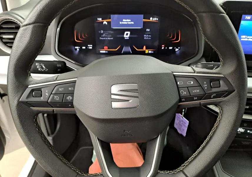 Vue rapprochée du volant multifonction noir de la SEAT Ibiza 2023 avec tableau de bord numérique allumé.