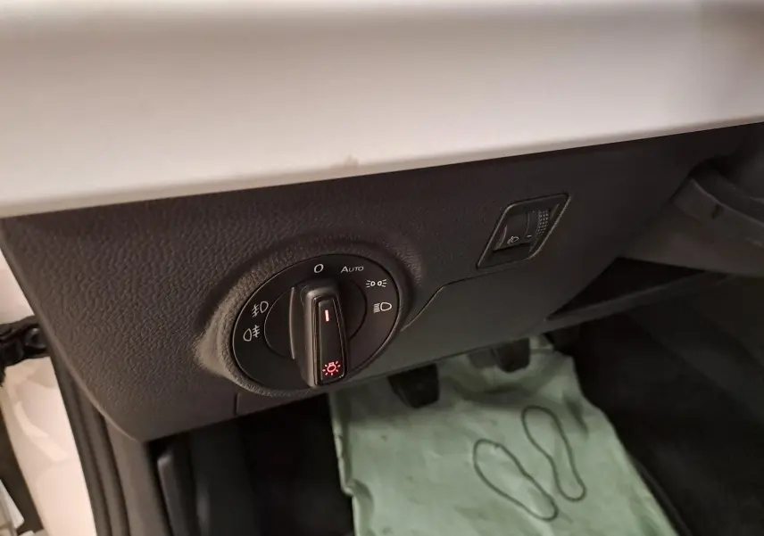 Gros plan sur le bouton de commande des phares dans l'habitacle d'une SEAT Ibiza blanc candy 2023.