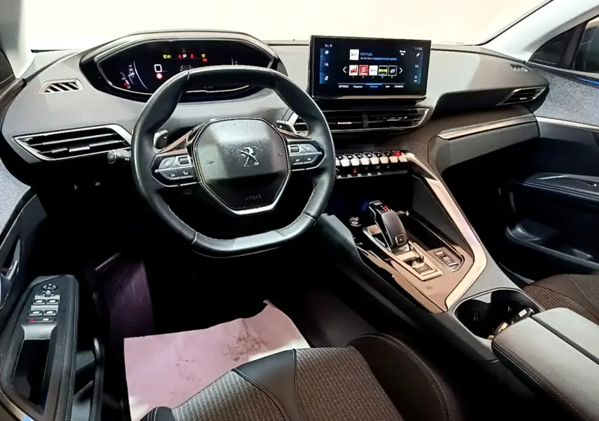 Intérieur du Peugeot 3008 gris foncé, vue côté conducteur sur volant cuir et écran tactile central lumineux.