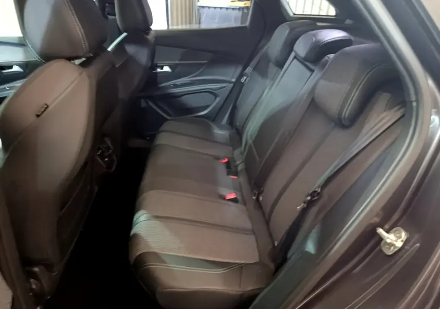 Vue côté droit de l'intérieur arrière gris foncé du Peugeot 3008 2022 avec sièges en cuir et tissu bicolore.