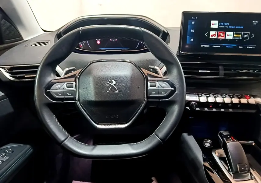 Vue intérieure centrée sur le volant cuir et tableau de bord tactile du Peugeot 3008 gris foncé 2022 Allure Pack.