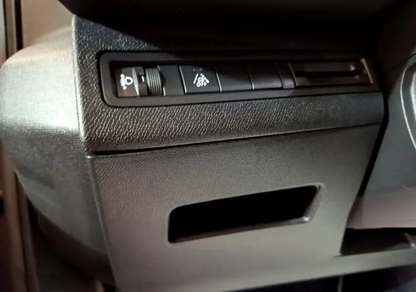 Détail du tableau de bord noir côté gauche avec commandes d'éclairage sur Peugeot 3008 gris foncé 2022