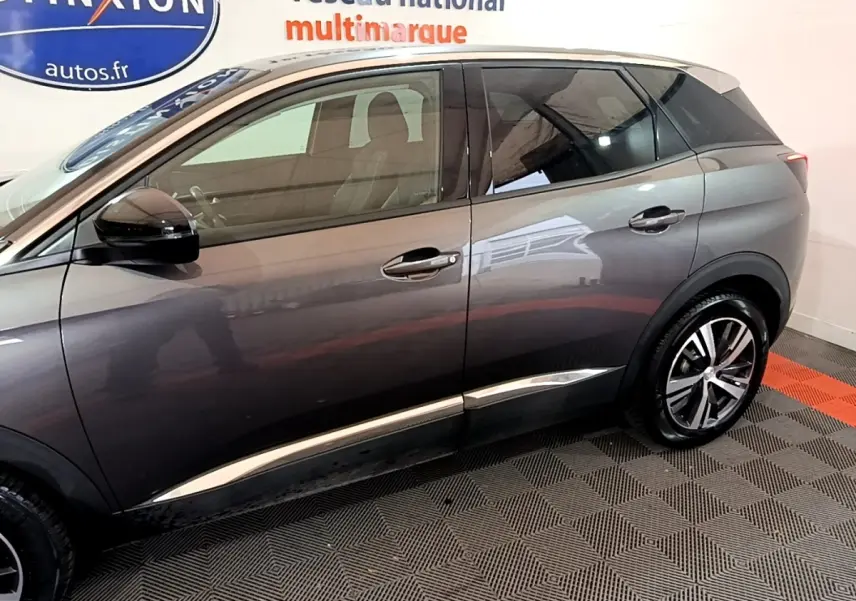 Profil côté gauche du Peugeot 3008 gris foncé 2022 avec jantes alliage et détails chromés sur les portières.