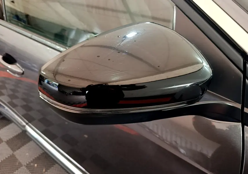 Rétroviseur droit noir brillant sur Peugeot 3008 gris foncé, vue rapprochée côté conducteur.