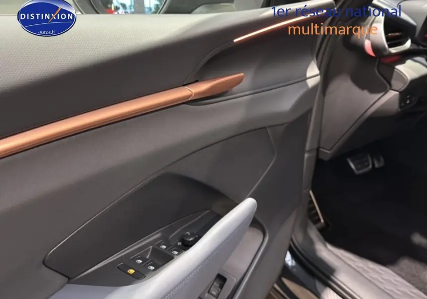 Vue intérieure côté conducteur de la CUPRA Terramar 2025 gris, avec garniture noire et insert cuivre sur la porte.