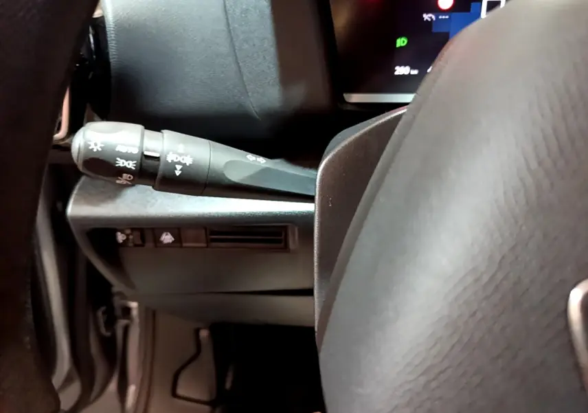 Gros plan sur la manette de commandes d’éclairage à gauche du volant gris foncé du Citroën C4 2021.