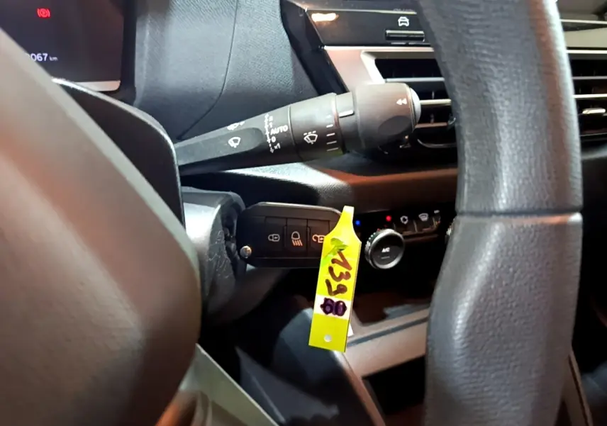 Gros plan intérieur sur la colonne de direction et commandes derrière le volant d'une Citroën C4 gris foncé, version 2021.