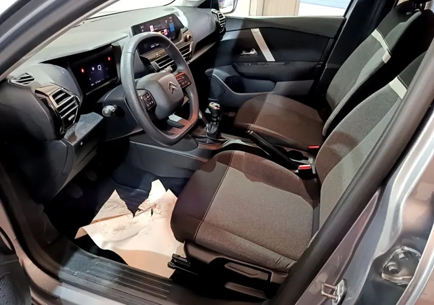 Intérieur avant droit de la Citroën C4 gris foncé 2021, volant multifonctions et tableau de bord avec écran tactile.
