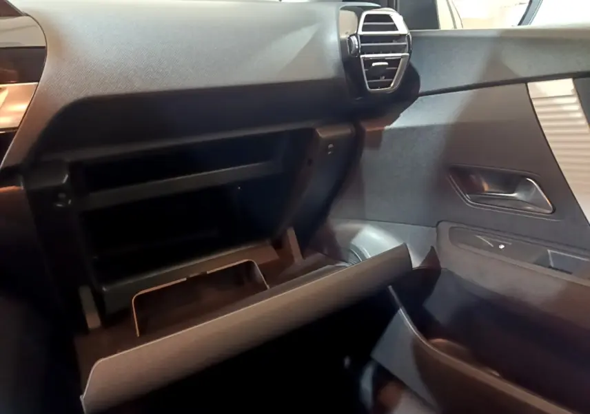 Intérieur de la Citroën C4 2021, vue côté passager sur la boîte à gants ouverte et la portière grise foncée.