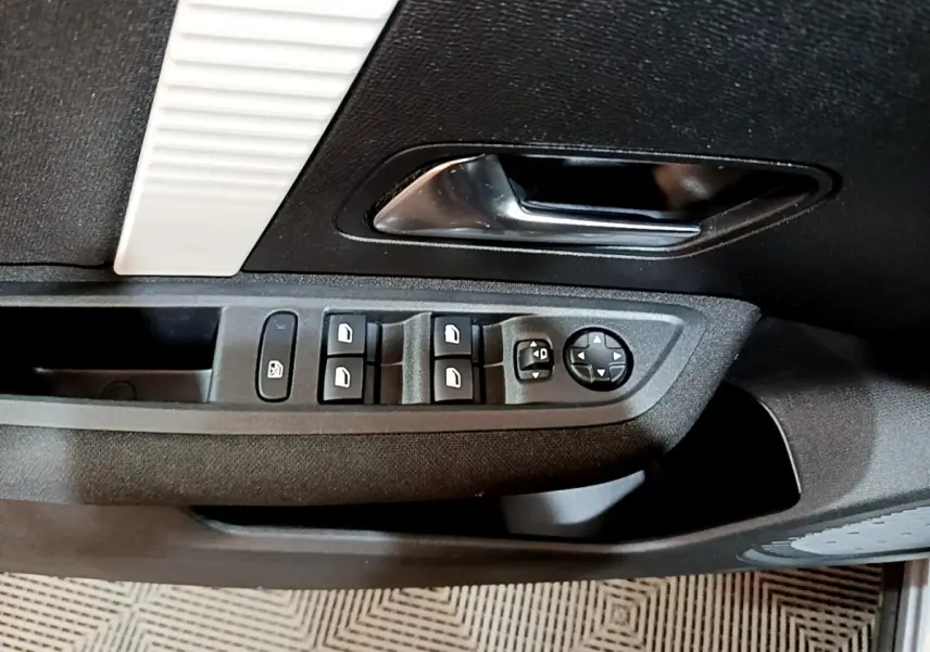 Vue rapprochée de la porte côté conducteur du Citroën C4 2021, montrant les commandes des vitres et rétroviseurs.