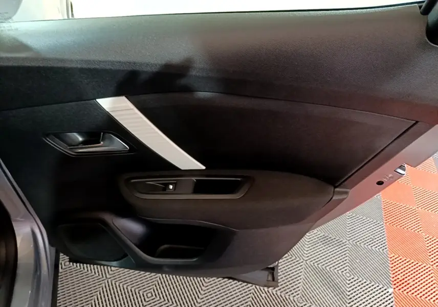 Vue rapprochée de la porte arrière gauche intérieure noire avec insert décoratif gris clair du Citroën C4 2021.