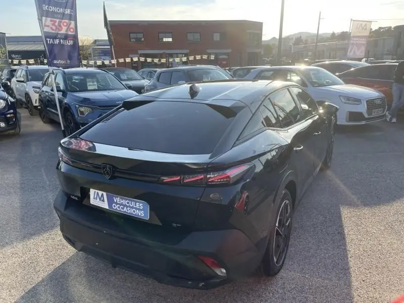 Vue 3/4 arrière droite d’une Peugeot 408 Hybrid 136 cv GT noir métal, avec feux arrière LED et toit incliné.