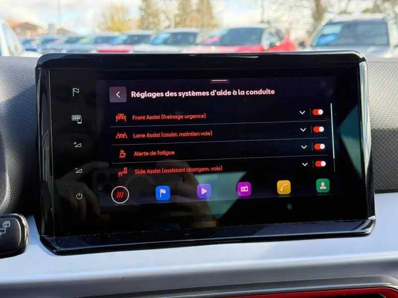 Écran tactile central du SEAT Arona 2025 affichant les réglages des aides à la conduite, intérieur moderne avec tableau de bord gris.