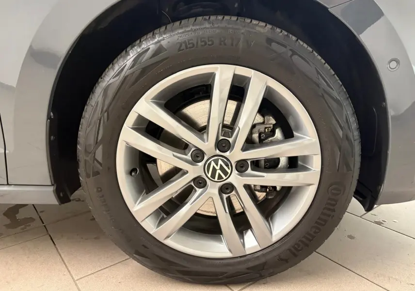 Gros plan sur la roue avant droite du Volkswagen Touran gris Dauphin, jante alliage et pneu Continental.