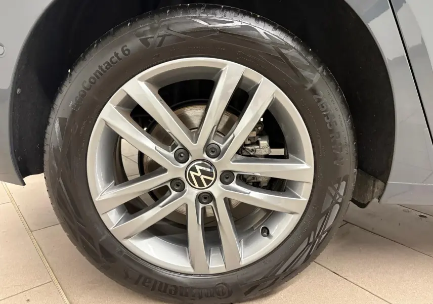 Gros plan sur la roue avant droite gris dauphin d’un Volkswagen Touran 2.0 TDI avec jante alliage 5 branches doubles.