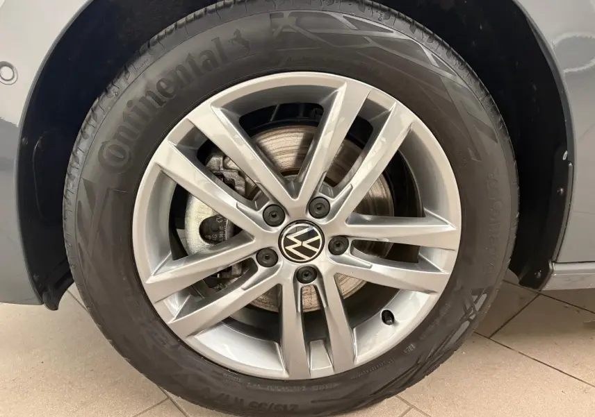 Gros plan sur la roue avant droite du Volkswagen Touran gris Dauphin, jante alliage 10 branches et pneu Continental.