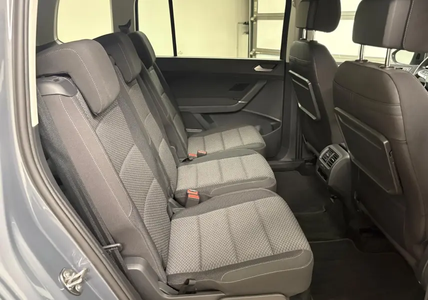 Vue latérale intérieure côté gauche montrant les trois sièges arrière gris avec appuie-têtes du Volkswagen Touran 2025.