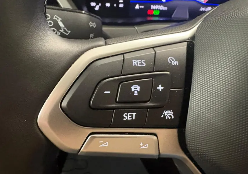 Gros plan sur les commandes au volant du Volkswagen Touran 2025, mettant en valeur les boutons de régulateur de vitesse.