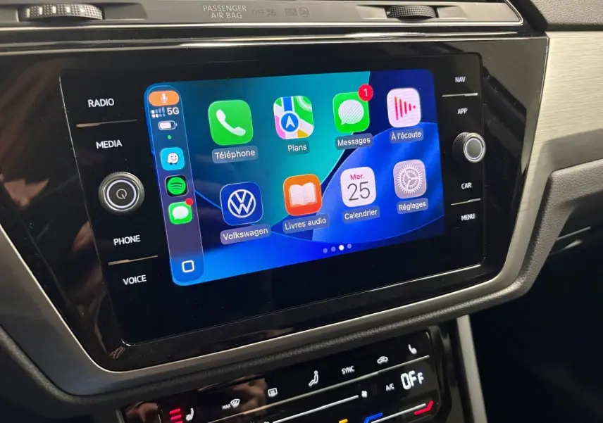 Écran tactile central du Volkswagen Touran 2025 affichant les applications Apple CarPlay, dans un intérieur noir et gris.