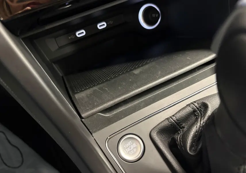 Gros plan sur la console centrale du Volkswagen Touran 2025, bouton Start Engine Stop et ports USB visibles.