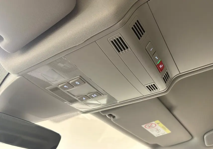 Vue intérieure du plafond avec commandes d'éclairage et ventilation du Volkswagen Touran 2025 gris Dauphin.