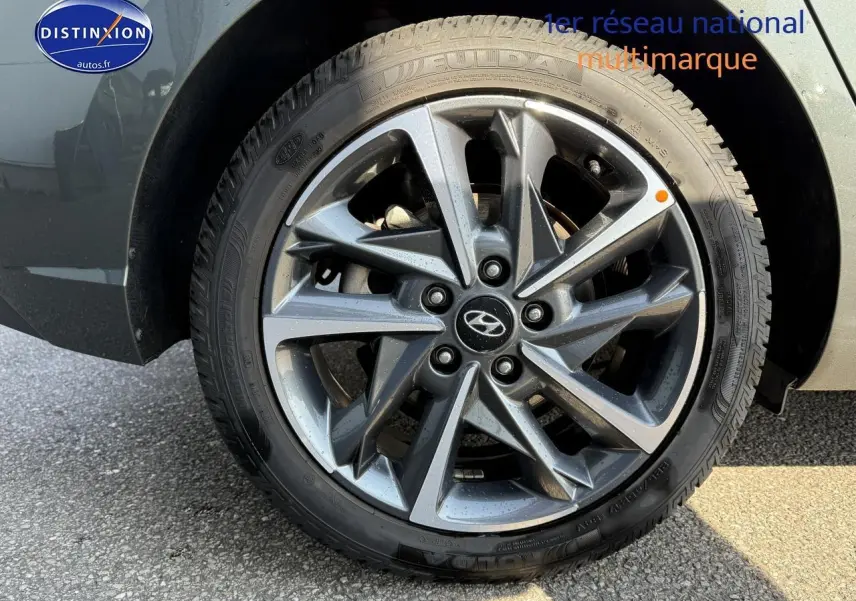 Gros plan sur la jante alu gris anthracite d'une Hyundai i30 2024 avec pneu hiver et logo Hyundai central.