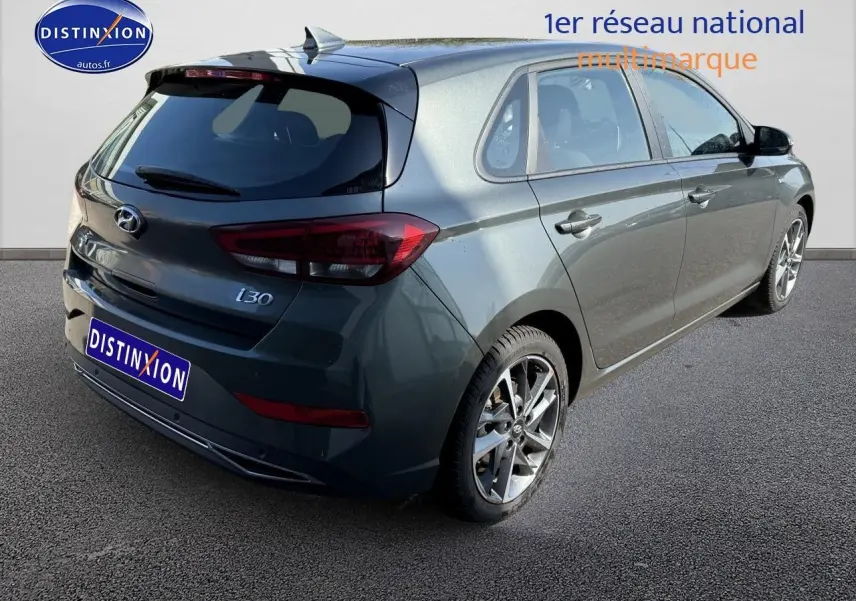 Vue 3/4 arrière droite d'une Hyundai i30 gris anthracite avec jantes alliage et feux arrière LED visibles.