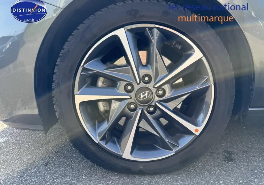 Gros plan sur la jante alu grise anthracite avec logo Hyundai d'une i30 2024 côté avant droit.