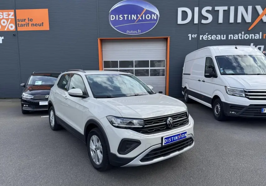 Volkswagen T-Cross gris Ascot en 3/4 avant droit, avec calandre noire et projecteurs LED visibles.